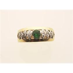 emerald and diamond ring The 14K and 18K yellow gold band style setting is surmounted by an oval...