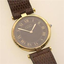 MIDSIZE CARTIER WRISTWATCH The round case is vermeil, the brown dial with Roman numerals, signed...