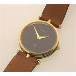 gucci wristwatch The round case has black enamelled detail with signature logo on back. The black...