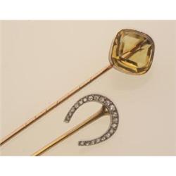 two antique stickpins First, an 18K yellow gold shaft supports a platinum horseshoe set with twen...