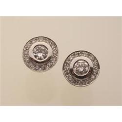 diamond earrings In white gold, two bezel set round brilliant cut diamonds totalling .66 carat ar...