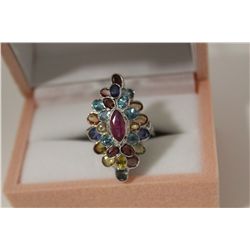 ONE LADIES STERLING SILVER COLOURED GEMSTONE SET COCKTAIL STYLE RING. THE RING IS BEZEL SET WITH A