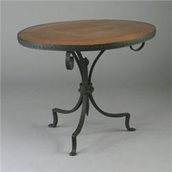 Rare MORGAN COLT circular wrought-iron table, the top covered in linen with a punched copper meda...