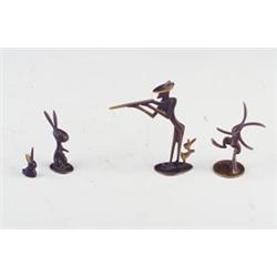 Four HAGENAUER figurines: hunter pointing gun with rabbit behind him, and three whimsical rabbits...