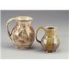 Image 1 : Two HENRY VARNUM POOR glazed redware pitchers: one with daisy motif and green leaves under a shee...