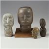 Image 1 : Four primitive carved soapstone heads: black with stylized torso and hair, large gray-brown, gray...