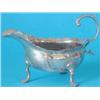 Image 1 : A George II silver sauceboat, with shaped rim and upscrolled leaf capped handle on three C scroll...