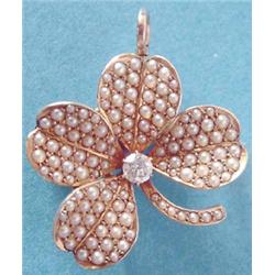 A 14k gold four leaf clover brooch/pendant pave set seed pearls and a central old brilliant cut d...
