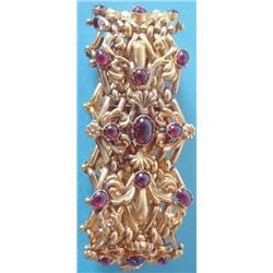 A Victorian gold and cabochon garnet set wide bracelet of 9 repousse work links worked shells, sc...
