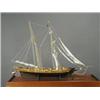 Image 1 : A wooden model of a twin masted sailing ship in a glazed case (ship 68cm high) Est. 100/200...