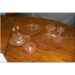 A selection of pink Depression style glassware including serving dishes, lidded casserole, cream and