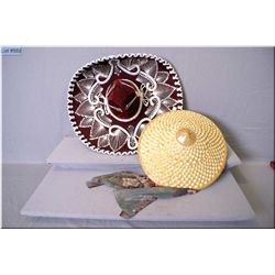 A Mexican sombrero and a Chinese sun hat and a large spoon and fork for the wall