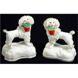 Pair of early 19th century Staffordshire porcelaineous standing poodles with red baskets in their…