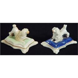 Two early 19th century miniature Staffordshire porcelaineous poodle on blue and a green cushion b…