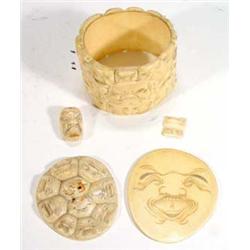 Oriental cylindrical ivory pot and cover, carved with grotesque heads…