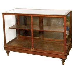 Showcase, oak floor model w/fancy cast iron feet, beveled glass top, oak shelf & sliding doors at re