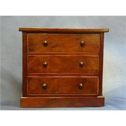 A Victorian walnutwood "apprentice" chest of 3 long drawers with tore handles, raised on a platfo...