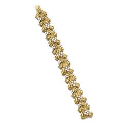 CARTIER A GOLD AND DIAMOND BRACELET Of abstract design, the wirework 18K gold links enhanced by b...