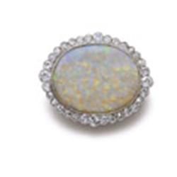AN OPAL AND DIAMOND BROOCH Designed as an oval-shaped opal cabochon within a circular-cut diamond...