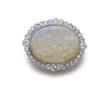 Image 1 : AN OPAL AND DIAMOND BROOCH Designed as an oval-shaped opal cabochon within a circular-cut diamond...