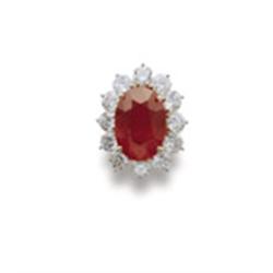 A RUBY AND DIAMOND RING The oval-shaped ruby weighing 10.21 carats within a surround of brilliant...