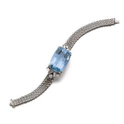 AN AQUAMARINE AND DIAMOND BRACELET Centering upon a shaped rectangular-cut aquamarine and enhance...