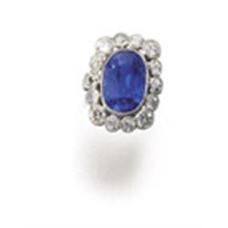 A SAPPHIRE AND DIAMOND RING The oval-shaped sapphire weighing 8.59 carats within a surround of br...