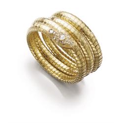 AN ANTIQUE GOLD AND DIAMOND SNAKE BANGLE The flexible bangle of snake scale design to the head se...