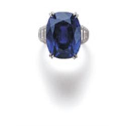 A SAPPHIRE AND DIAMOND RING The cushion-cut sapphire weighing 23.69 carats to the tapering should...