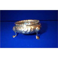 AN EMBOSSED CIRCULAR SILVER SALT CELLAR, LONDON, 1859, BY HENNELL, raised on three hoof feet, 7...