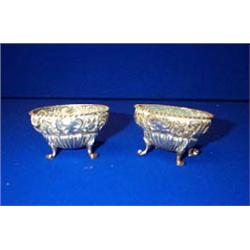 A PAIR OF OVAL EMBOSSED SALT CELLARS, BIRMINGHAM, 1901, with ogee shaped bowls, each raised on fo...