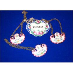 A SET OF THREE ENAMEL DECANTER LABELS; Port; Sherry; and Whiskey; and another (4)....