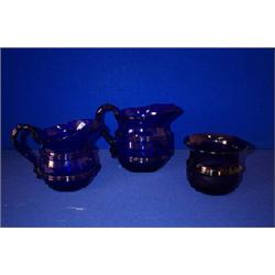 TWO SIMILAR BLUE JUGS, c.1800, PROBABLY WATERFORD, with double corded bodies, 14cms and 12cms hig...