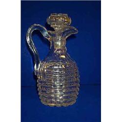 A CUSHION CUT CLARET JUG, c.1840, with faceted shoulders and star cut base, with associated stopp...