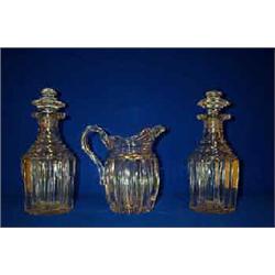 A PAIR OF PILLAR CUT FULL SIZE DECANTERS, c.1840, 32cms high, with associated stoppers; and a sim...