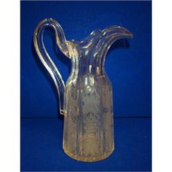 A FACETED CLARET JUG, 19th CENTURY, engraved with fruiting vines with loop handle, 27cms high.<...