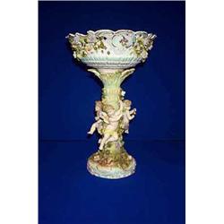 A GERMAN CENTREPIECE, LATE 19th CENTURY, the form of amorini disporting a rose clad palm bough ho...