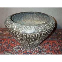 A brass MIDDLE EASTERN EMBOSSED POT, with a band of calligraphy, 47cms wide....