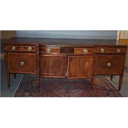 A MAHOGANY BOWED BREAKFRONT SIDEBOARD, IRISH, BASICALLY LATE 19th CENTURY, the frieze drawer with...