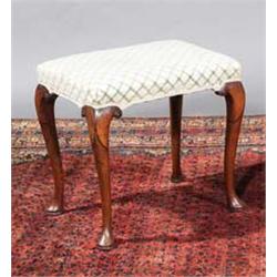 A WALNUT FRAMED STOOL, 18th CENTURY, on a lappet cabriole legs with pad feet, scroll brackets,...