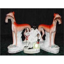 A pair of 19th century Staffordshire figures of greyhounds with hares in their mouths, height 28...