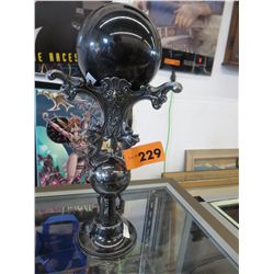 Ornate stand with black marble orb