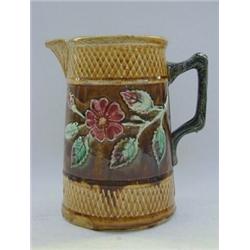 A MAJOLICA PITCHER, c.1880, moulded band of briar roses, branch handle, pink interior, height 20c
