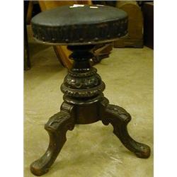 A stained beech swivel piano stool on tripod carved foot £70-90