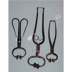 THREE WROUGHT IRON SUGAR NIPPERS. The largest with shaped springs on the interior handles and a r…