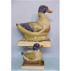 TWO DUCK PIPSQUEAKS. Papier-mache handpainted with blue heads and tails. The smaller is on a bask…