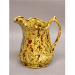 ENGLISH POTTERY PITCHER. Unusual mottled pale yellow and brown glaze. Octagonal base with paneled…