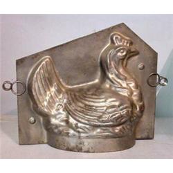 TWO TIN MOLDS. Two-part hen with wire clips. 8 1/4"l. And oval with strawberries. Minor pitting. …