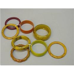 EIGHT MARBELIZED BAKELITE BANGLE BRACELETS. Shades of green, red, butterscotch, and amber. One is…