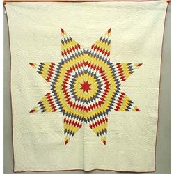 PIECED LONE STAR QUILT. Bright red, yellow, purple, tan, and white diamonds make up the graphic s…